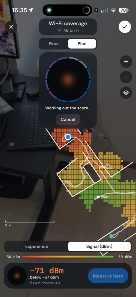 A tela do app no escritório: o mapa do local sobre a imagem da câmera, com o ponto sendo medido.